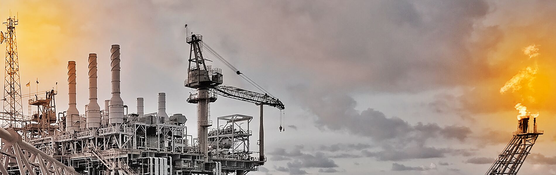 Offshore oil and gas industry with piping and valves, worker in foreground